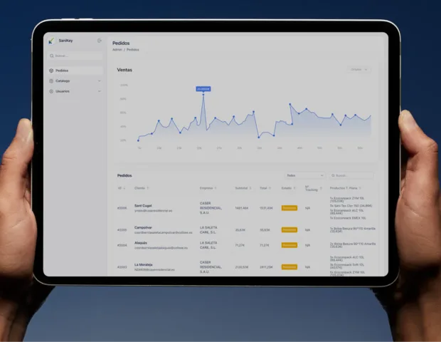 Hands holding a tablet showing an orders dashboard
