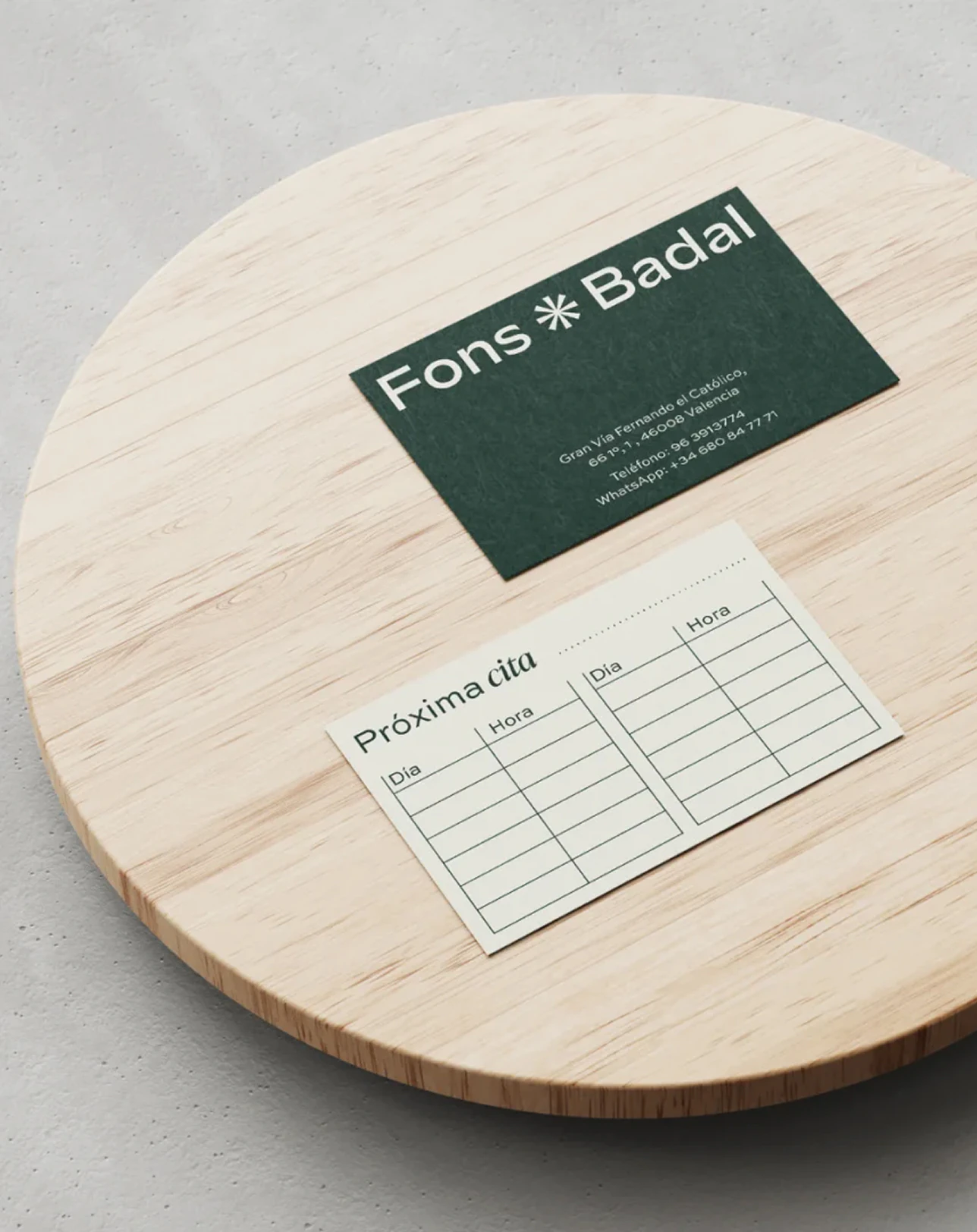 Tarjeta de visita y tarjeta de próxima cita de Fons Badal sobre una tabla de madera
