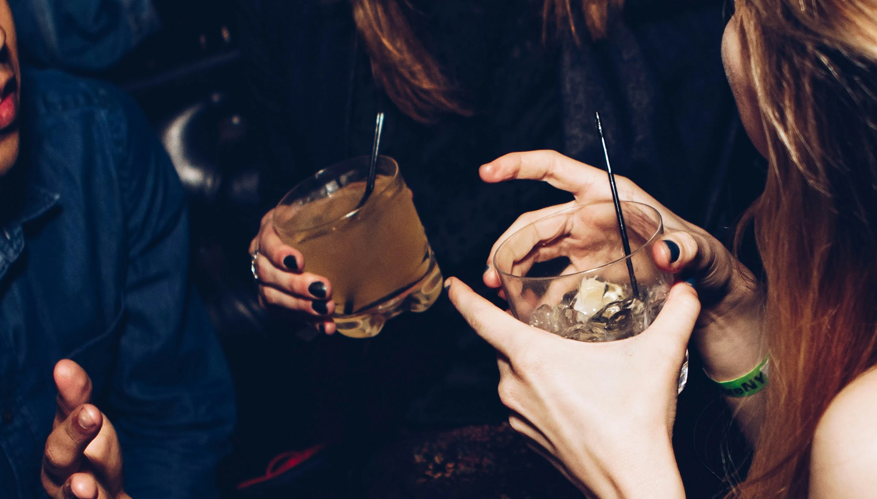 Manos que brindan con copas y cócteles en una noche de fiesta