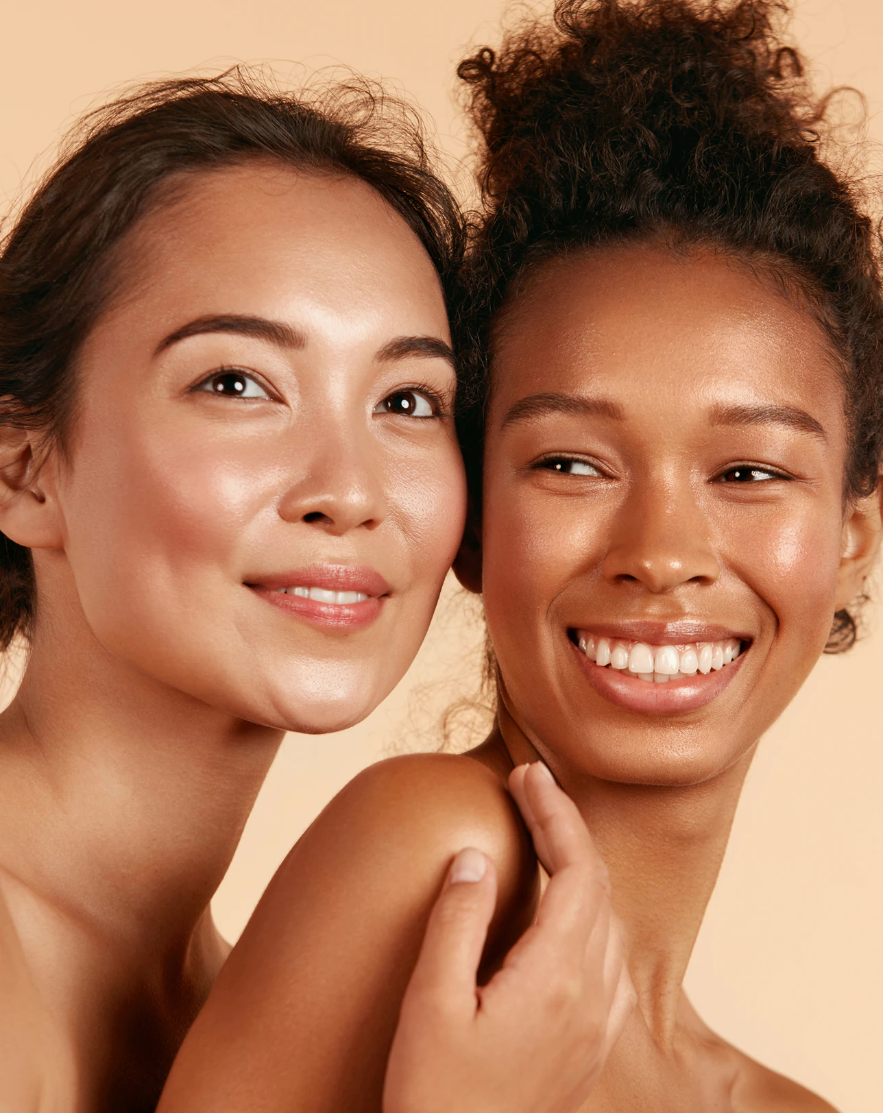 Dos mujeres sonrientes, mejilla con mejilla