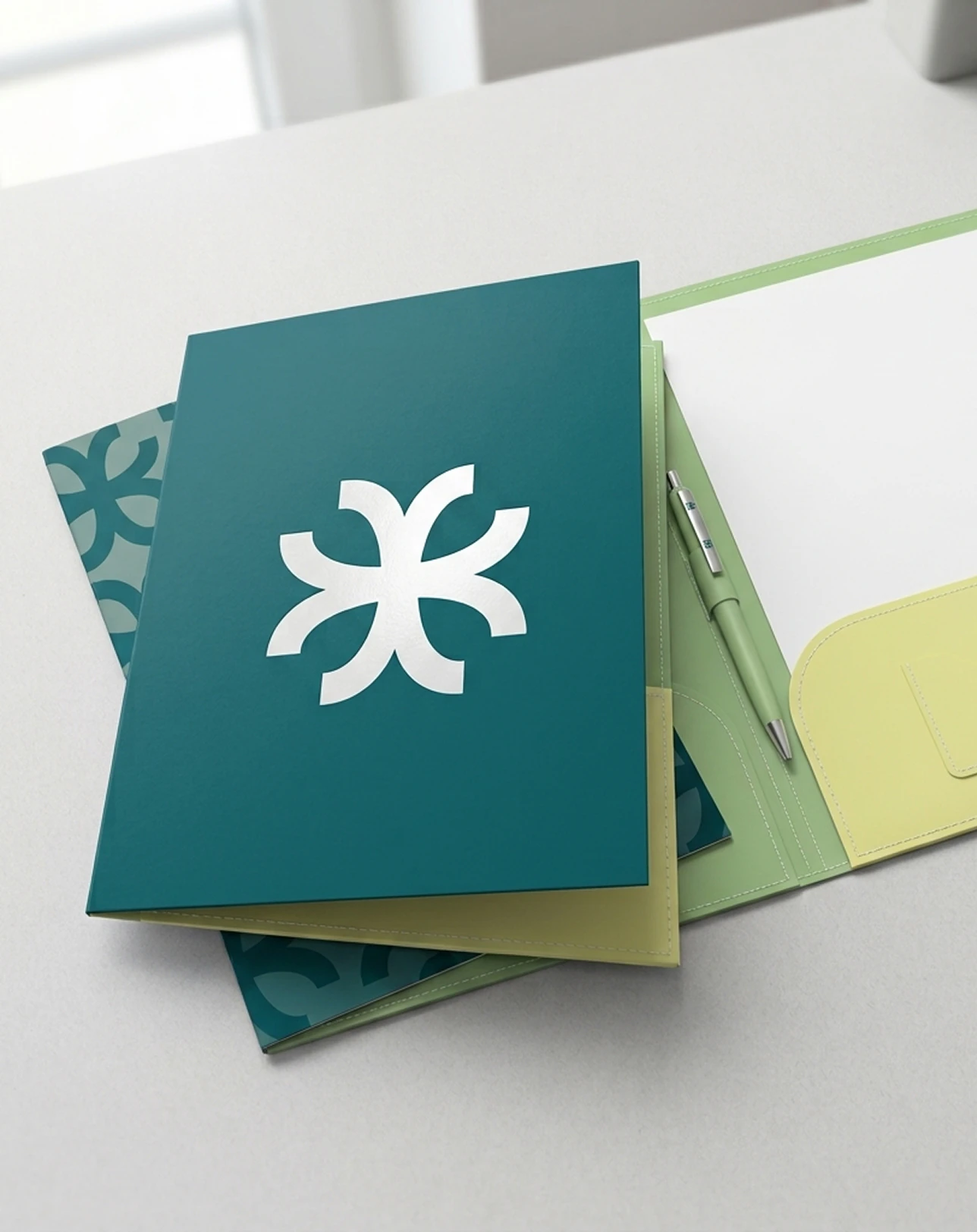Carpeta verde azulado con el símbolo de Viviq, sobre una mesa blanca